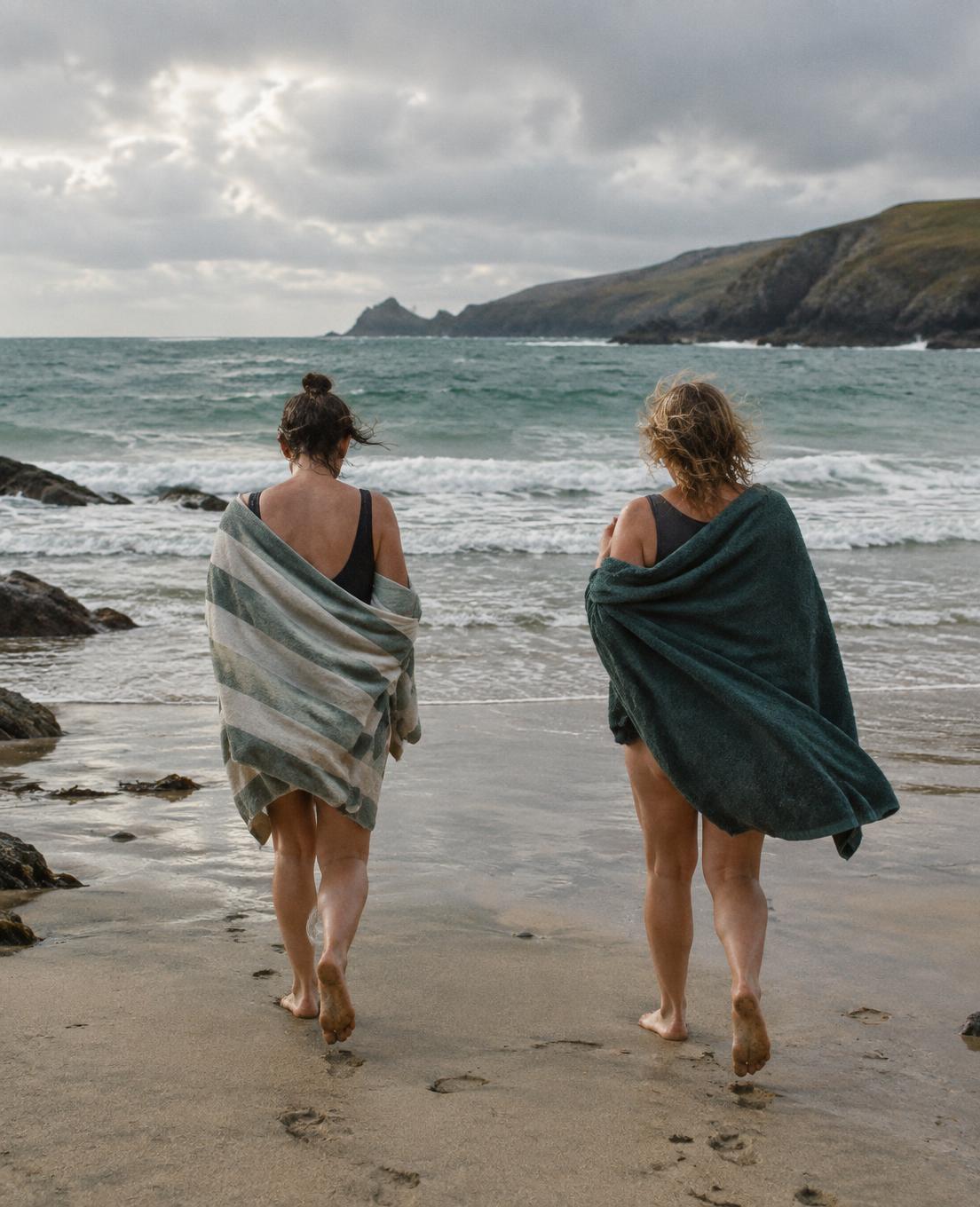 Two people walking into the sea together